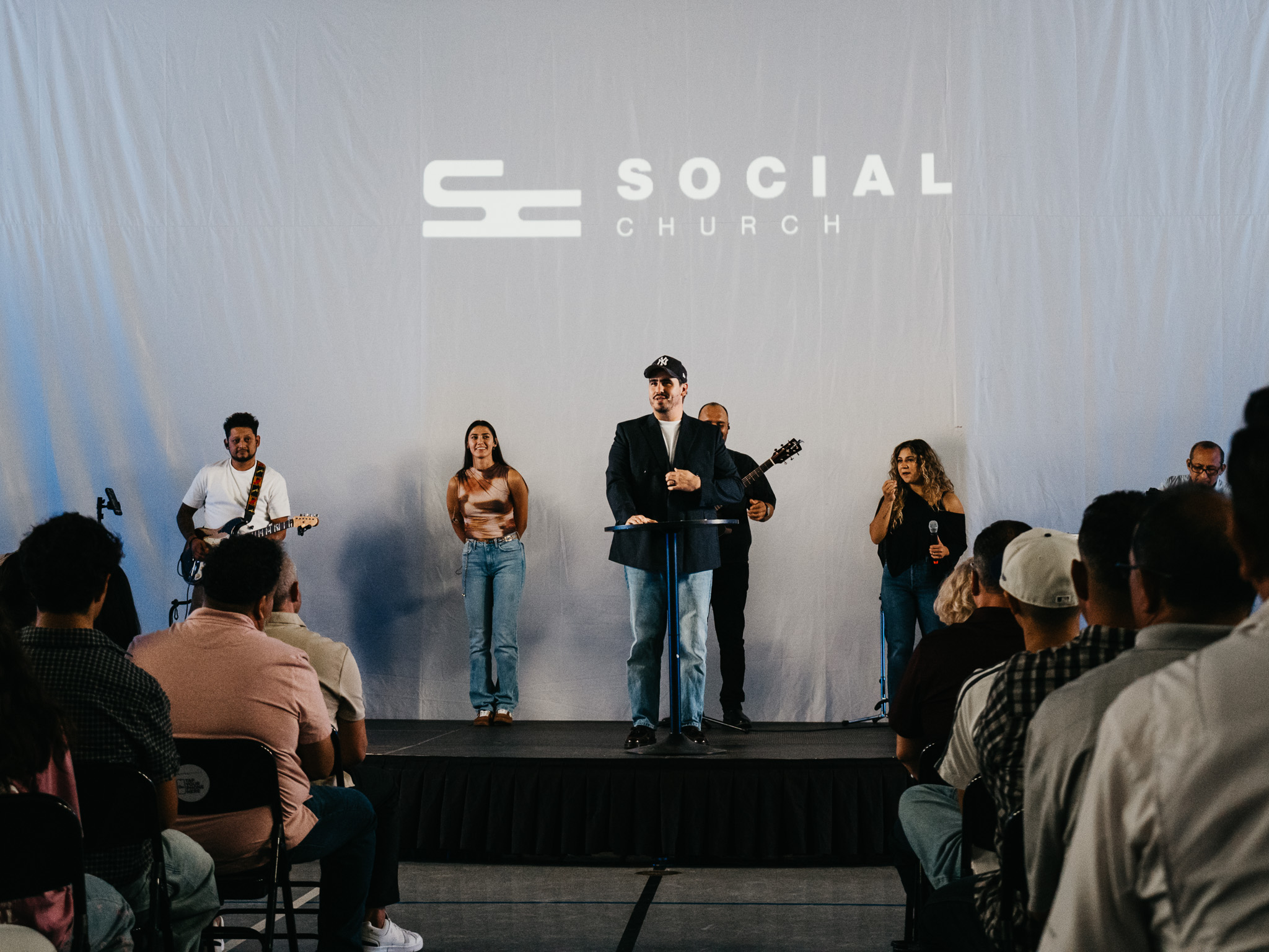 Social Church gathered with the speaker and worship team on stage.